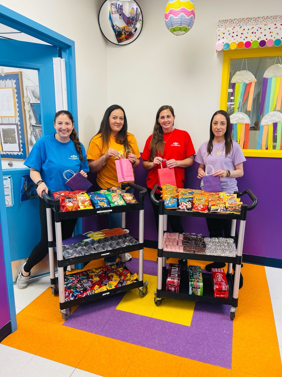Four team members with candy carts piled high with snacks